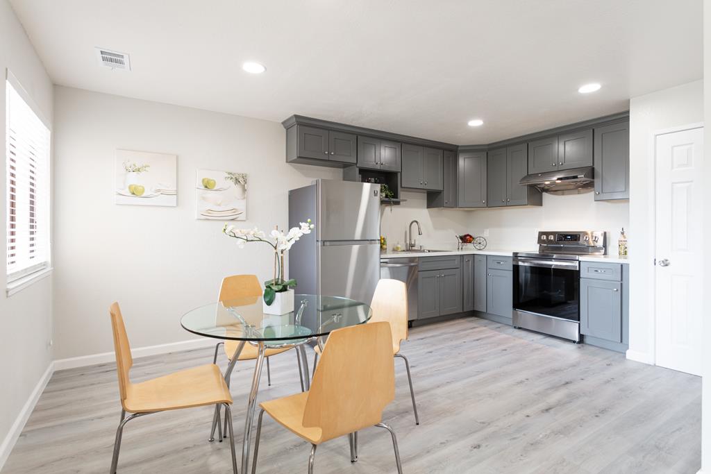 93 Shaniko Common, Unit 24 Fremont, CA 94539 - Photo 9 of 25 a kitchen with a table chairs refrigerator and microwave