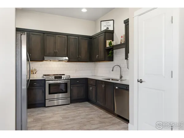 a kitchen with stainless steel appliances granite countertop a refrigerator and a sink