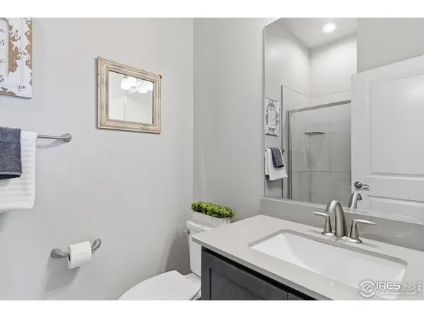 a bathroom with a granite countertop sink a toilet and mirror