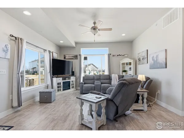 a living room with furniture a flat screen tv and a large window