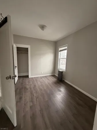 an empty room with wooden floor and window