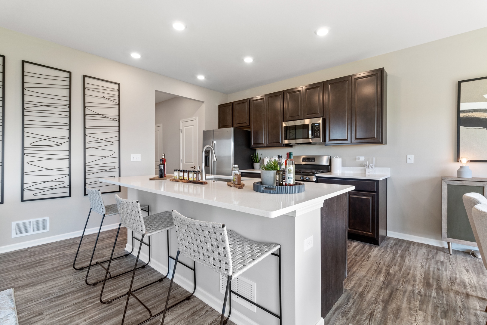 25626 West Springview Drive Plainfield, IL 60586 - Photo 6 of 27 a kitchen with stainless steel appliances a microwave a stove a sink dishwasher a stove and a refrigerator with wooden floor
