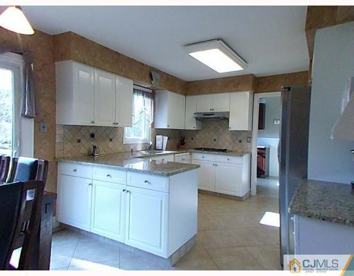 15 Lynnwood Road Edison, NJ 08820 - Photo 4 of 9 a kitchen with granite countertop a sink cabinets and window