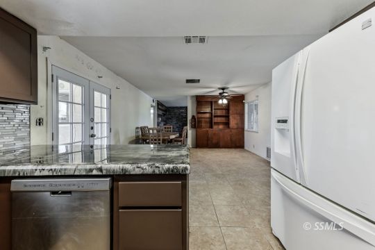 301 South Lincoln Street Ridgecrest, CA 93555 - Photo 9 of 20 a large kitchen with granite countertop a refrigerator and a sink