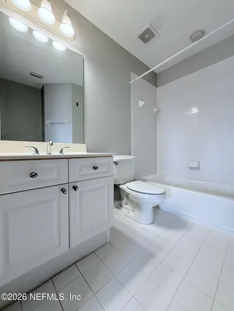 a spacious bathroom with a toilet sink and a mirror