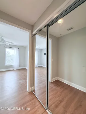 a view of a hallway with wooden floor