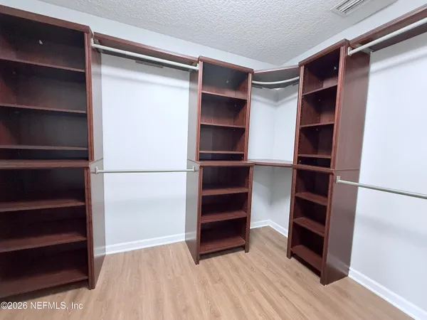 a view of walk in closet with empty racks