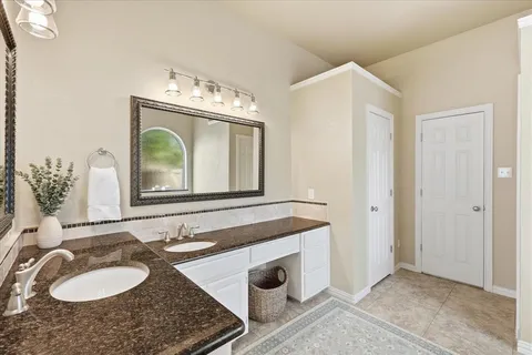 a bathroom with a granite countertop sink and a mirror