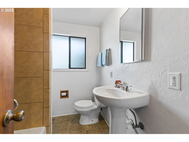 a bathroom with a sink toilet and mirror