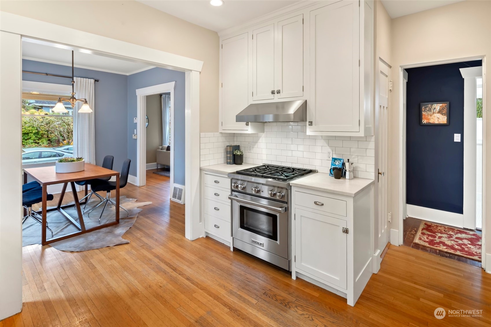 2226 12th Avenue East Seattle, WA 98102 - Photo 11 of 37 a kitchen with stainless steel appliances a stove a sink and white cabinets with wooden floor