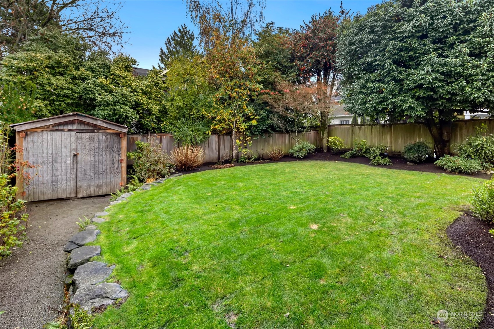 2226 12th Avenue East Seattle, WA 98102 - Photo 30 of 37 a view of a backyard with large trees and wooden fence