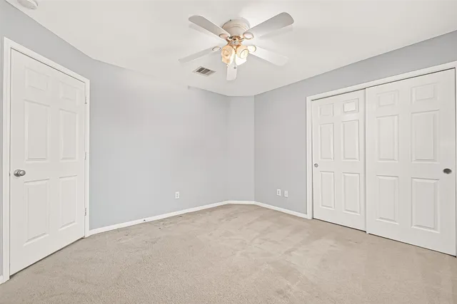 a view of an empty room with a ceiling fan