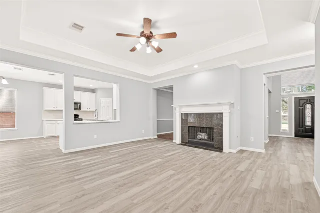 wooden floor fireplace and windows in an empty room
