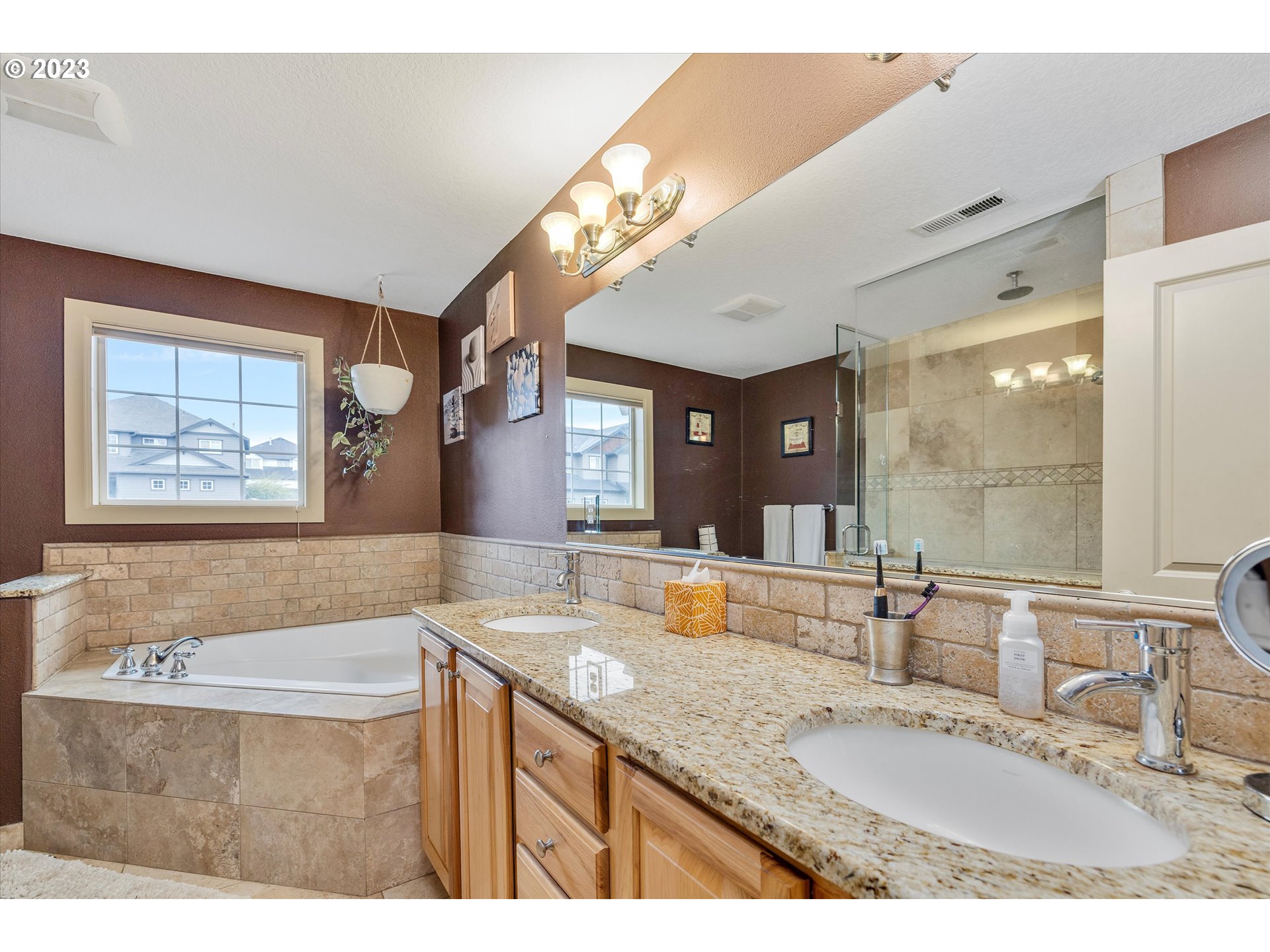 16472 Southeast Siri Loop Damascus, OR 97089 - Photo 20 of 41 a bathroom with a granite countertop sink a large mirror and a bathtub