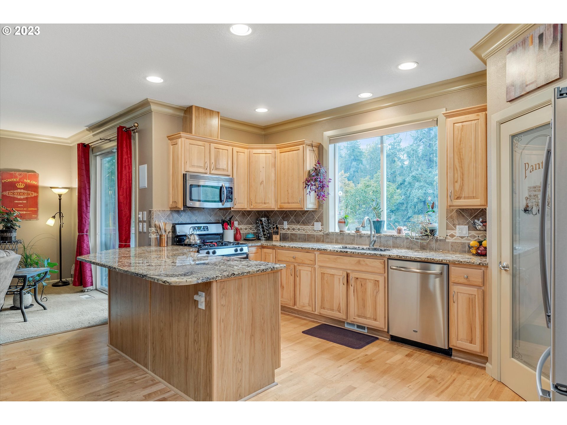 16472 Southeast Siri Loop Damascus, OR 97089 - Photo 10 of 41 a kitchen with kitchen island granite countertop a sink cabinets and wooden floor