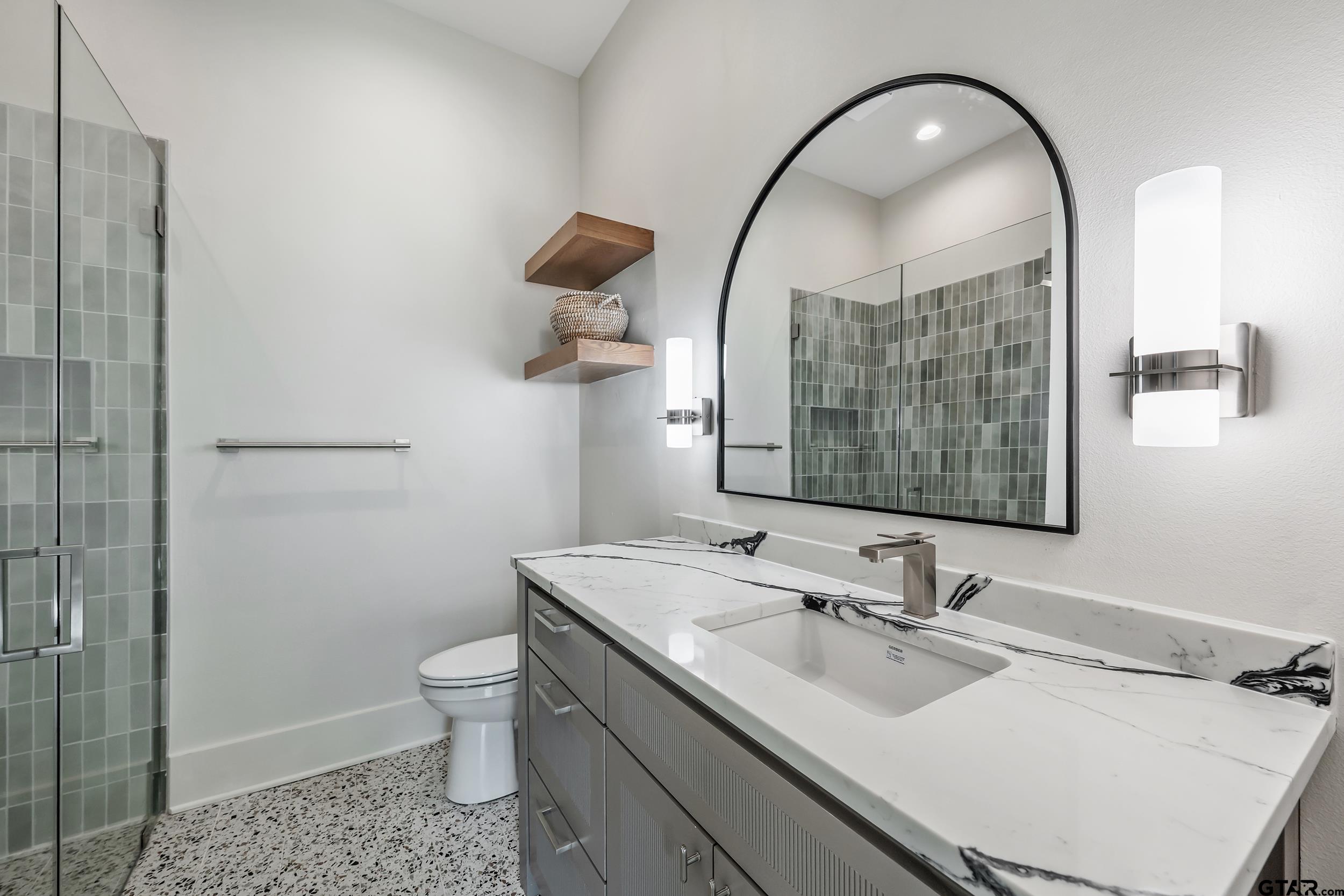 1409 Canopy Cv Court Tyler, TX 75703 - Photo 24 of 40 a bathroom with a sink a toilet and a mirror