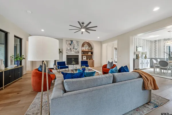 a kitchen with stainless steel appliances granite countertop a stove top oven a sink a dining table and chairs with wooden floor