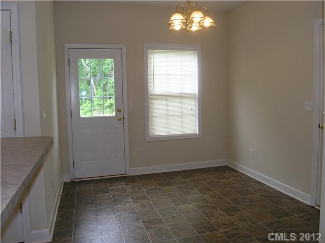 5767 Grassy Creek Road Denver, NC 28037 - Photo 4 of 11 an empty room with chandelier fan and windows