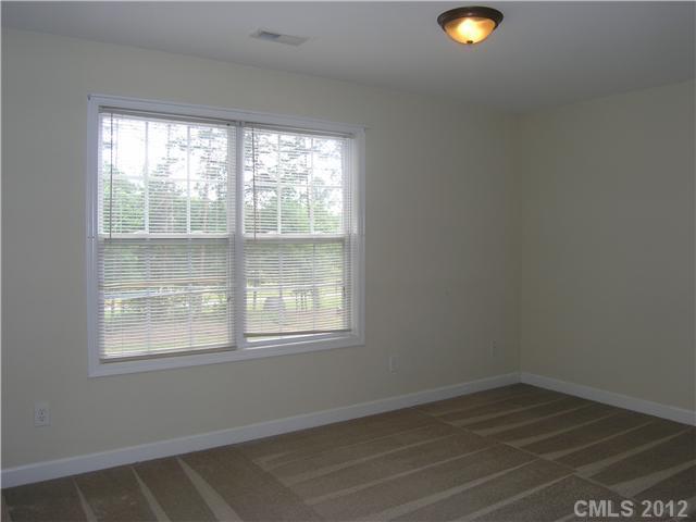 5767 Grassy Creek Road Denver, NC 28037 - Photo 6 of 11 an empty room with wooden floor and windows