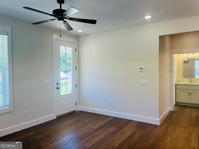 a view of a room with wooden floor and a ceiling fan