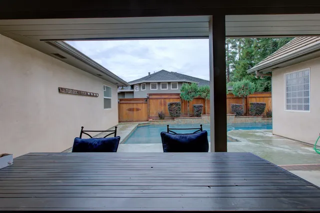 a view of a backyard with chair and potted plants