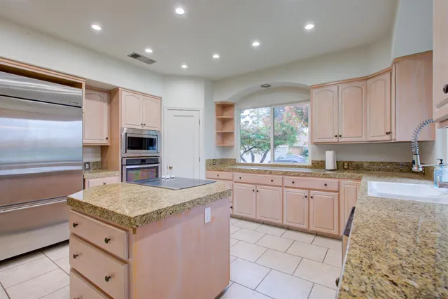 a kitchen with granite countertop sink and cabinets