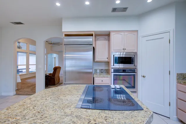 a kitchen with stainless steel appliances granite countertop a stove a sink and a refrigerator