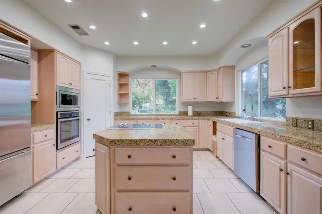 a kitchen with granite countertop kitchen island white cabinets and white appliances