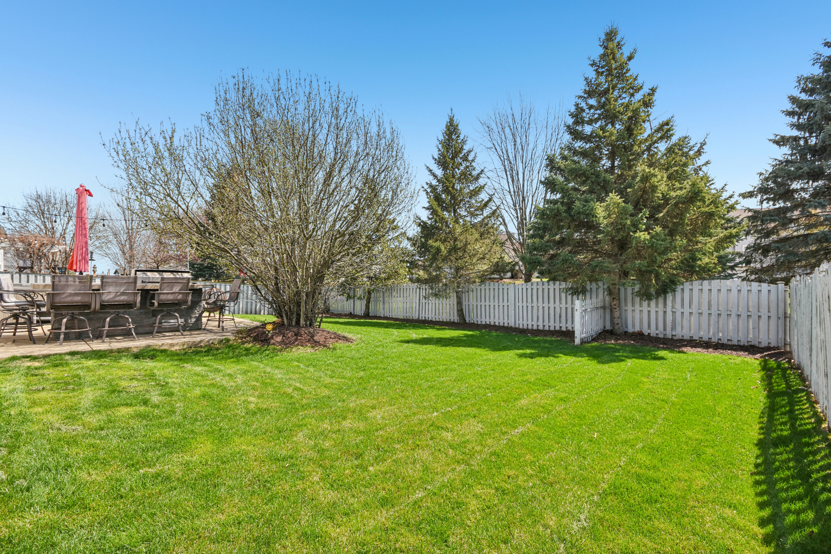 1739 Newbridge Circle Elgin, IL 60123 - Photo 41 of 42 a view of a backyard with wooden fence and a large tree