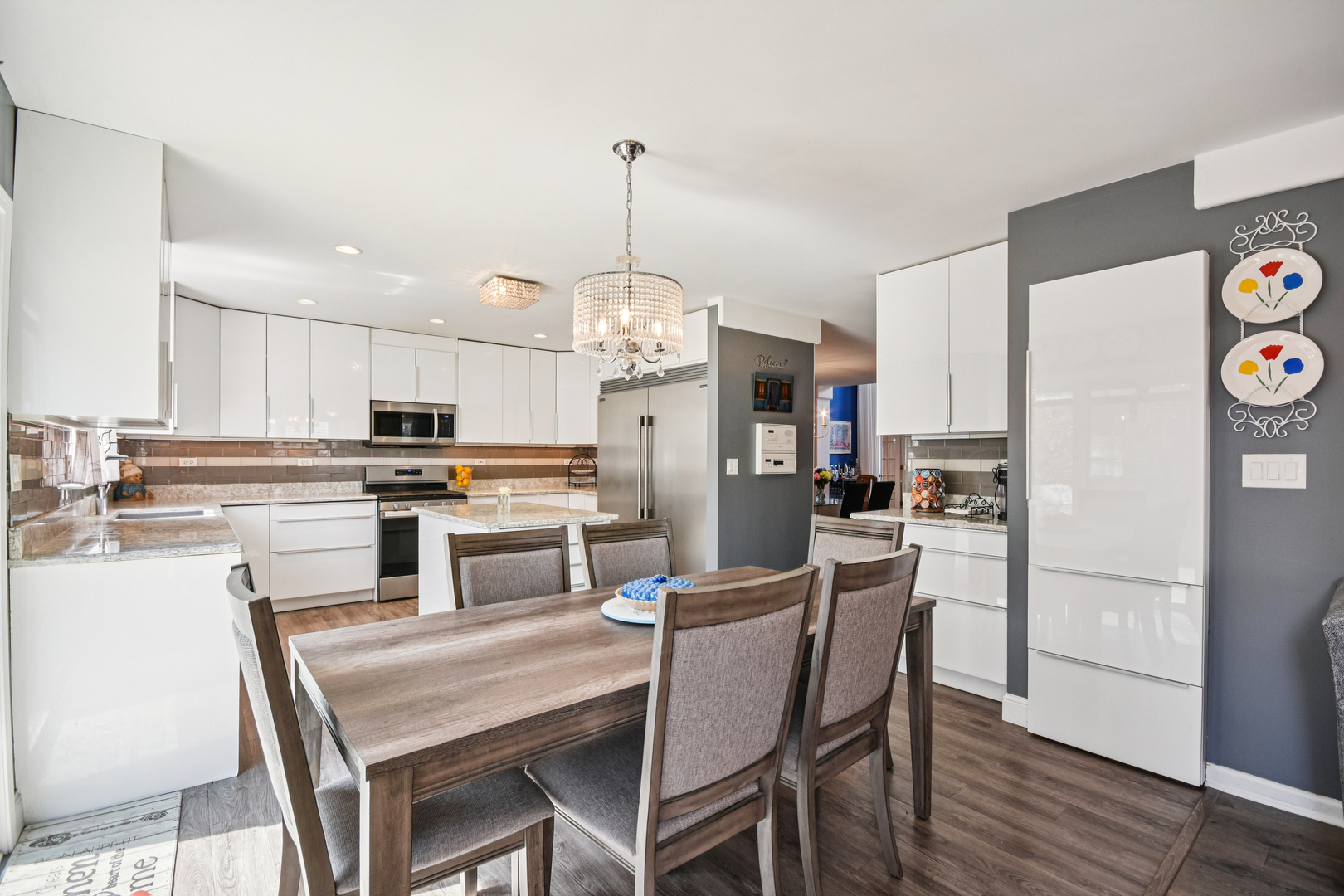 1739 Newbridge Circle Elgin, IL 60123 - Photo 10 of 42 a kitchen with a dining table chairs refrigerator and microwave