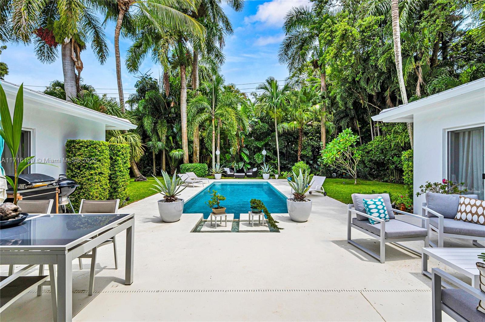 203 Ridgewood Road Coral Gables, FL 33133 - Photo 32 of 46 a view of a patio with table and chairs potted plants and palm tree
