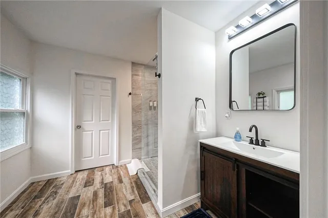 a bathroom with a shower sink and mirror