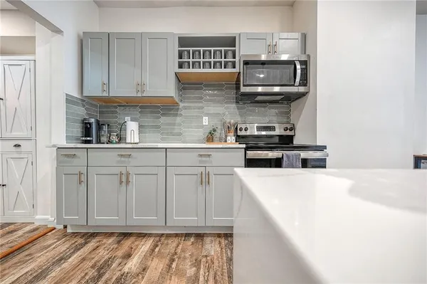 a open kitchen with sink a microwave and cabinets