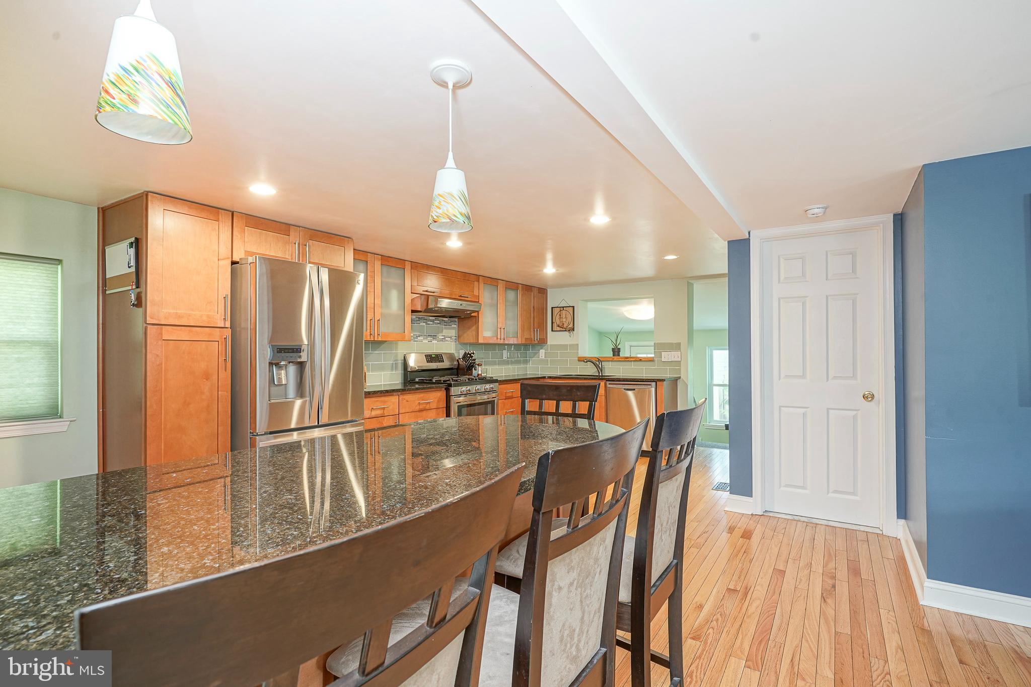 407 Hamilton Road Glassboro, NJ 08028 - Photo 4 of 31 a kitchen with stainless steel appliances kitchen island granite countertop a refrigerator a stove and a sink with wooden floor