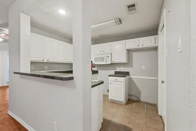 a kitchen with white cabinets and white appliances