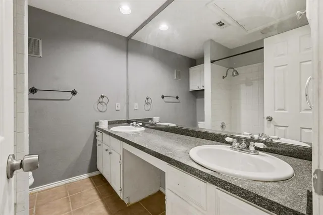 a bathroom with a granite countertop sink a mirror and a shower