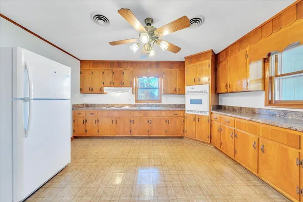 a large kitchen with stainless steel appliances granite countertop a refrigerator and a sink