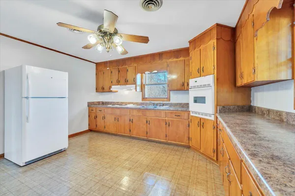 a kitchen with stainless steel appliances granite countertop a sink refrigerator and cabinets