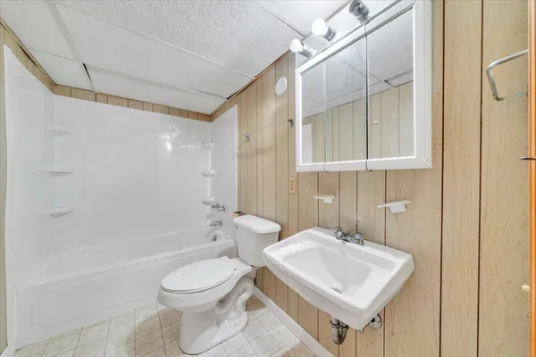 a bathroom with a toilet a sink and bathtub