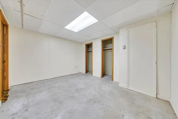 an empty room with closet and a hallway