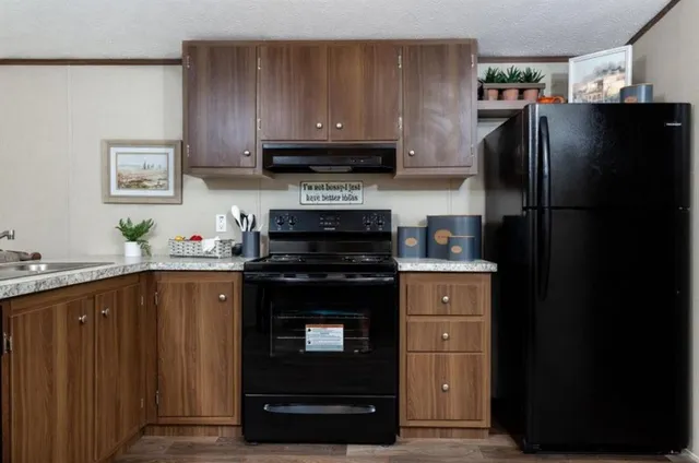 a kitchen with stainless steel appliances granite countertop a refrigerator and a sink