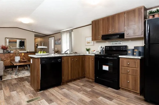 a kitchen with stainless steel appliances granite countertop a refrigerator a stove a sink and a microwave