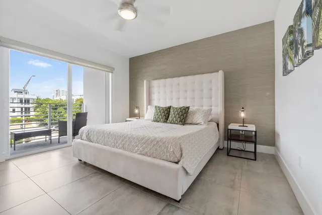 a bedroom with a bed and a flat tv screen on the dresser
