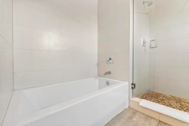 a bedroom with a bed and a flat tv screen next to a large window