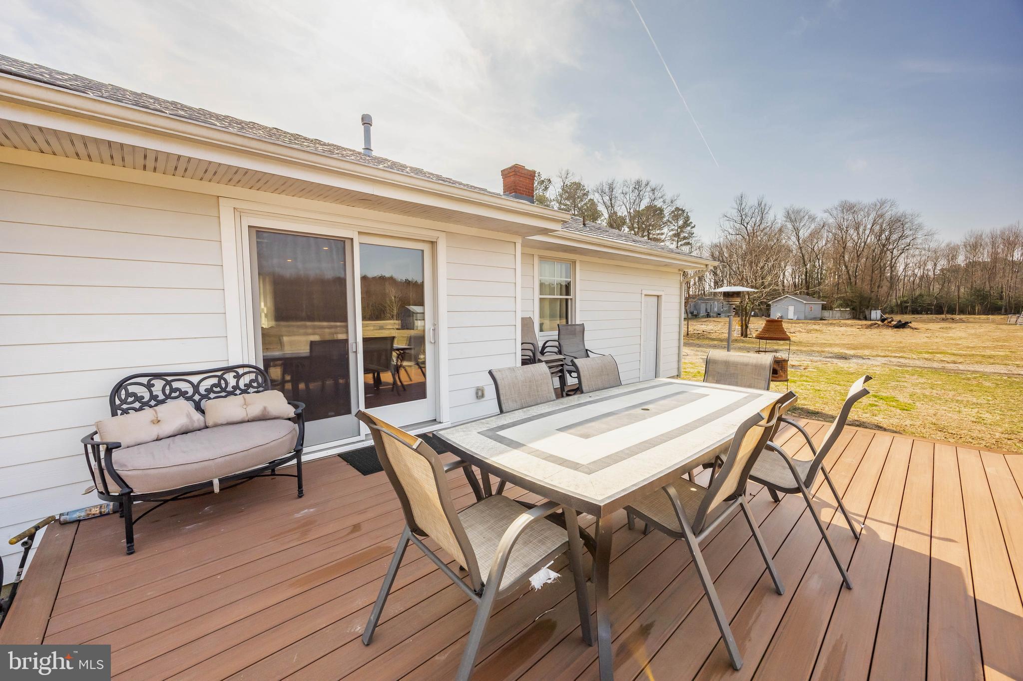 14470 Backbone Road Eden, MD 21822 - Photo 39 of 55 a view of a roof deck with table and chairs a barbeque with wooden floor and fence