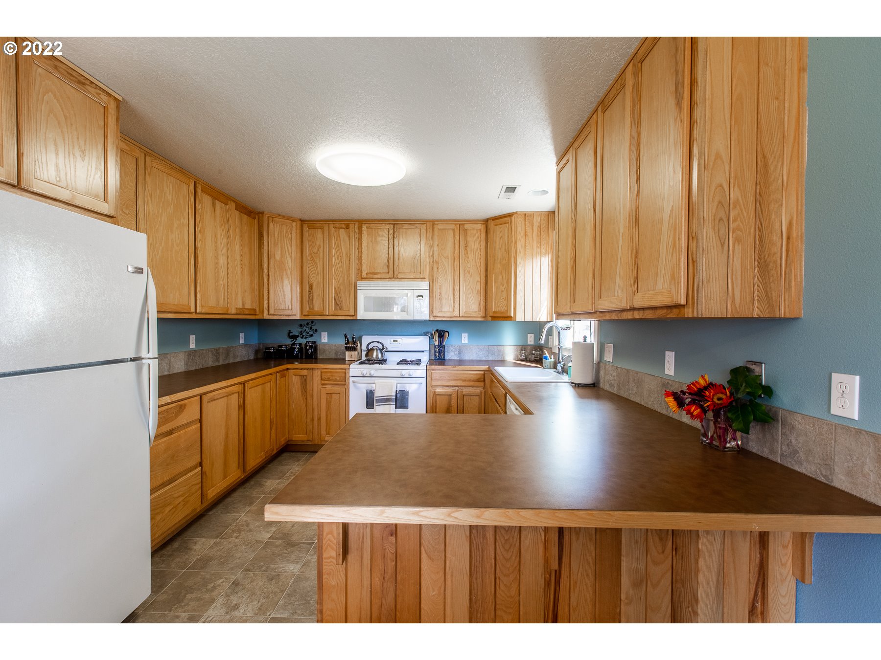 5363 I Street Springfield, OR 97478 - Photo 10 of 29 a kitchen with stainless steel appliances granite countertop a refrigerator a sink dishwasher a stove and white countertops with wooden floor