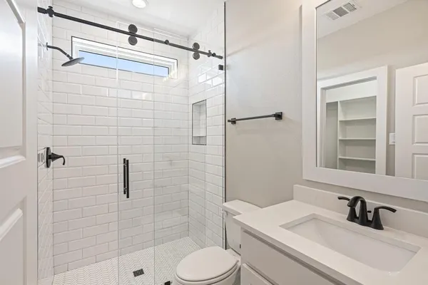 a bathroom with a sink a toilet and shower