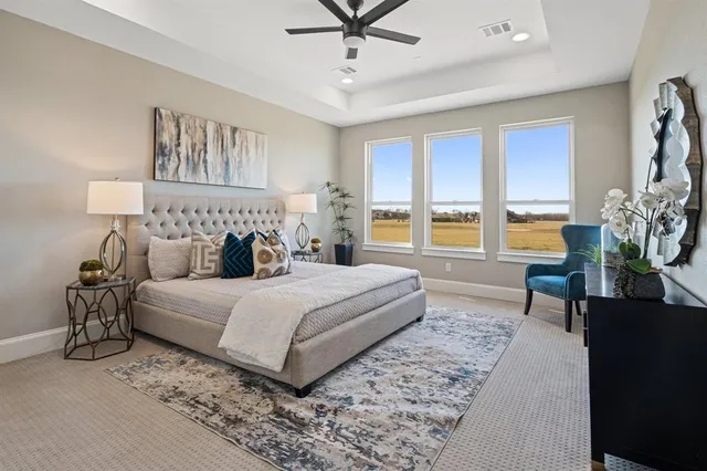 a bedroom with a large bed and a chandelier fan