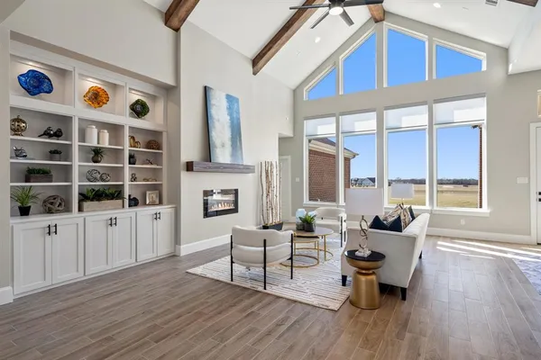 a living room with fireplace furniture and a large window