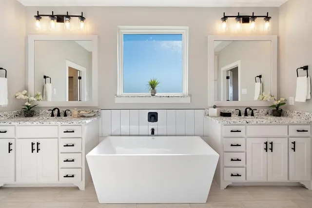 a bathroom with a bathtub sink and mirror